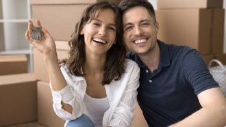 Casal sorridente com uma criança e um cão ao colo
